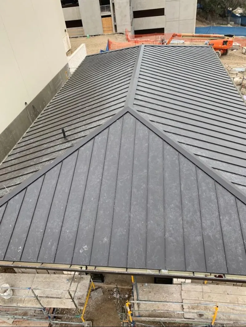 Commercial metal roof construction with crane equipment in Marina